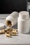 Food supplement pills in white plastic bottle. Capsules, collagen, vitamins, pain killers or drugs