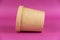 Food to take away. Closed cylindrical paper container with lid opposite colored background. Brown food container for soup, ice