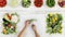 food top view hands cutting zucchini on white chopping board