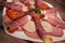 Food tray with delicious salami, pieces of sliced ham, sausage, Deli meats, Pickles