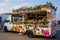 A food truck adorned with colorful flower paintings parked on a bustling city street, Food truck with a floral design theme, AI