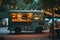 A food truck is parked in front of a tent at an outdoor event as people enjoy dining and socializing, A food truck in a