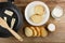 Food turner, butter in frying pan, slices of bread in plate with milk, salt, pitcher with jug on table. Top view