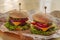 food. Two hamburger with cutlet grilled, lettuce, tomato, cheese, cucumber on a light wooden background