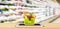 Food and vegetables in shopping basket on mobile smartphone on wood table with supermarket aisle blurred background grocery