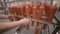 Food warehouse. Worker putting sausages on a rack in a food factory warehouse.