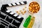 Food for watching film. Popcorn and soda near clapperboard, glasses on grey background top view copyspace