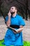 Fooling around handsome bearded man in blue kimono with finger in nose sitting and holding book