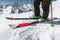 Foot athlete skier in professional ski boots on snow. A close-up of the skis on the athlete`s legs against the