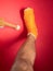 Foot with broken toe bone in orange fiberglass cast pink background. Injured fractured swollen male leg. Patient body