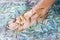 Foot, fish and a person in water for pedicure treatment closeup from above in Thailand. Spa, skincare and relax with