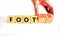 Foot or footloose symbol. Businessman turns wooden cubes and changes word Foot bad to Footloose. Beautiful white table white