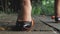 Foot girl close up in black patent-leather shoes crushed a mandarin on a concrete tile in the street and pierces with a heel. foot