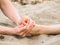 Foot massage in sand, male and female caucasian