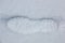 Foot print of a human shoe on the white snow