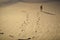 Foot prints and a explorer in the sand in Blur style. Tiltâ€“shift photography.