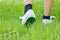 Foot in sneaker walking on grassland