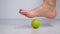 foot step on massage ball to relieve Plantar fasciitis or heel pain. woman with red pedicure massaging trigger points on