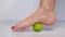 foot step on massage ball to relieve Plantar fasciitis or heel pain. woman with red pedicure massaging trigger points on