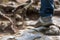 Foot tourist on slippery stones close-up