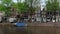 Footage of canal, boats, historical and traditional buildings, trees, cars and bicycles in Amsterdam.