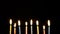 Footage colorful burning candles set on black background. 4k
