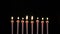 Footage colorful burning candles set on black background. 4k