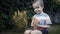 Footage farm boy holding a small chick in the hands outdoor.