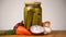 Footage glass jars with salted vegetables for the winter rotated on table.