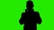 Footage of man`s silhouette wearing medical mask on green background