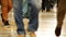 A footage of people`s legs striding across the shopping center wearing different shoes and trousers