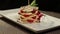 Footage of a portion of pancakes decorated with strawberries on a plate lying on a table, the shot is rotating on a table