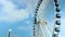 footage of the white and blue Ferris wheel turning with blue sky and clouds in motion on an autumn day at Navy Pier in Chicago