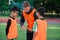 Football coach instruct teen football players. Young professional coach explains for kids the strategy of the game.