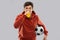 Football fan with soccer ball blowing horn