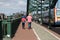 Football fans walking away from camera along pavement sidewalk on match day