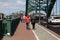 Football fans walking away from camera along pavement sidewalk on match day