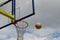Football flies to the basketball ring against the cloudy gray sky