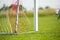 Football goal detail with a soccer players in the background. Football soccer pitch.