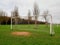 Football goal post on a training ground. Worn out grass on a keeper spot. Soccer theme background