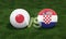 Football with Japan vs. Croatia 3D ball soccer flags on green football field