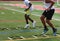 Football players running a ladder agility drill at summer camp