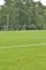 On a football practise and on a green field on a rainy, cold and grey Autumn afternoon with soccer players on a background