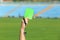 Football referee holding green card and whistle at stadium