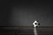 Football soccer ball indoors in a dark moody room near the concrete gray wall.