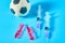 Football, soccer ball near syringe and ampoule on blue background. Concept of doping in professional sport