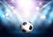 Football / soccer ball under spotlights with bokeh lights