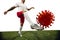 Football or soccer player kicking, punching model of coronavirus - fighting with epidemic concept