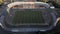 Football stadium in the city park. A green field and stands are visible, painted in different colors. Close-up shot. Aerial