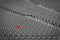 Football stadium with empty seats. Outstanding empty red plastic chair at soccer arena. Row of unoccupied bench at sports stadium.